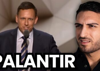 Fremder Mann bei einer Diskussion, Hintergrund: Mann spricht in einem Mikrofon, „PALANTIR“-Schriftzug, Business, Technologie, Innovation, Datenanalyse, kritisch, professionell, Medien.