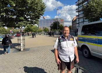 Sicherheitskräfte und Polizei im öffentlichen Stadtbild, Einsatz bei einem städtischen Ereignis, Sicherheitspräsenz in der Innenstadt, Polizei-Uniformen, städtische Szenerie mit Polizeifahrzeug und Passanten.